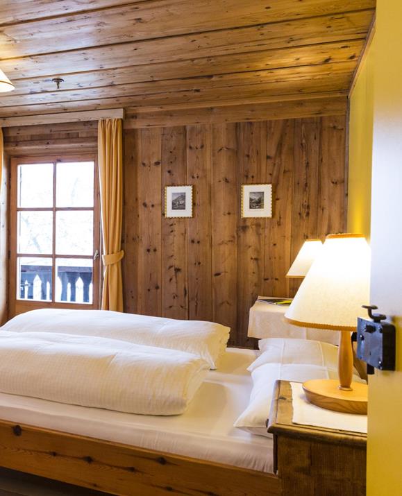 Das holzvertäfelte Doppelzimmer Zirbe mit Doppelbett, Balkon und Einrichtung im rustikalen Stil