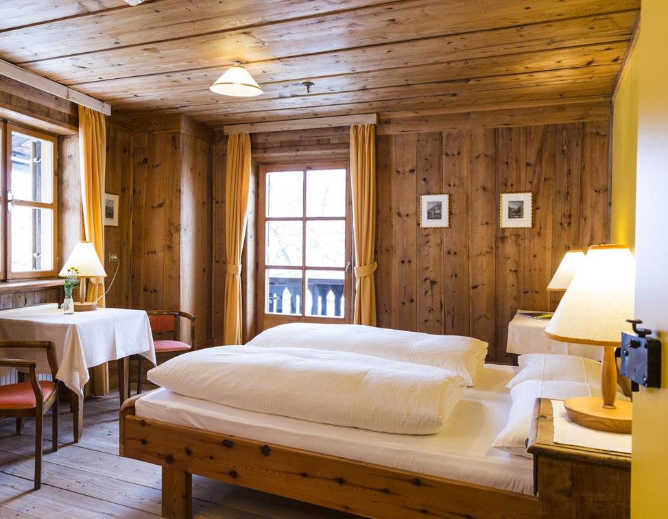 The wood-paneled Pine double room with a double bed, balcony and rustic furniture