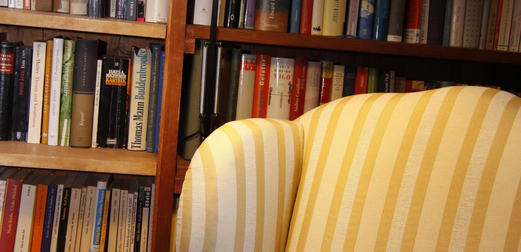 A shelf full of books and an armchair in our library