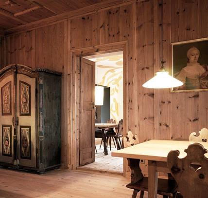 Unsere traditionelle Stube mit holzvertäfelten Wänden, verzierten Stühlen und antikem Bauernschrank