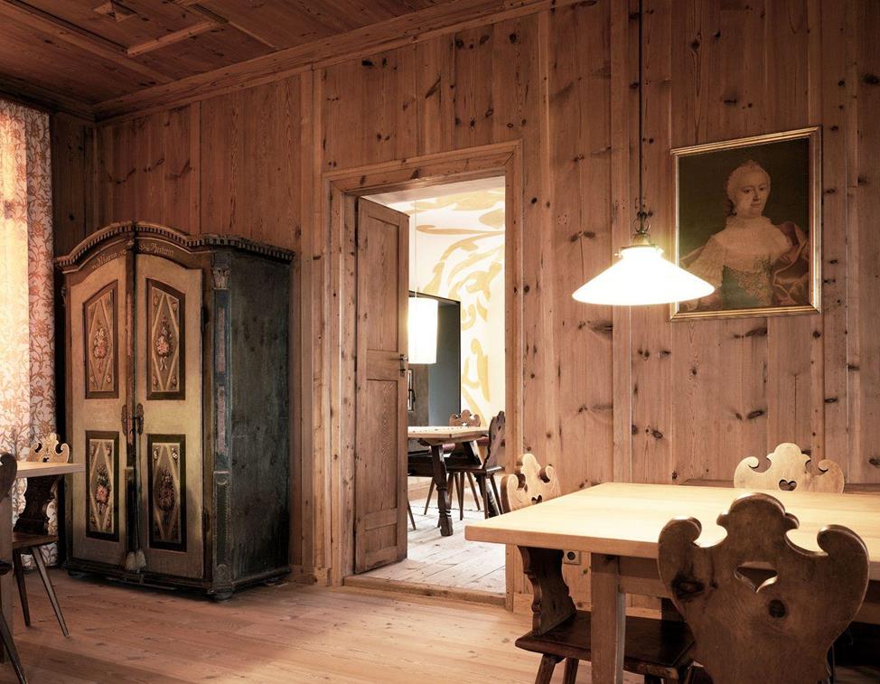 La nostra Stube tradizionale con pareti rivestite in legno, sedie intagliate e un armadio contadino antico