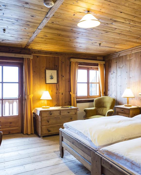Das holzvertäfelte Doppelzimmer Panorama mit zwei Einzelbetten, Balkon und rustikaler Einrichtung