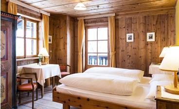 Das holzvertäfelte Doppelzimmer Zirbe mit Doppelbett, Balkon und Einrichtung im rustikalen Stil