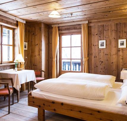 Das holzvertäfelte Doppelzimmer Zirbe mit Doppelbett, Balkon und Einrichtung im rustikalen Stil