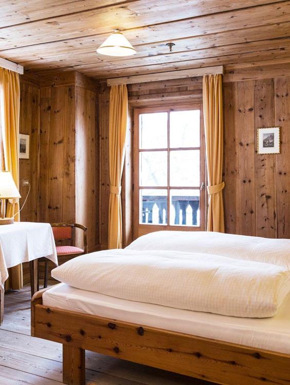 Das holzvertäfelte Doppelzimmer Zirbe mit Doppelbett, Balkon und Einrichtung im rustikalen Stil