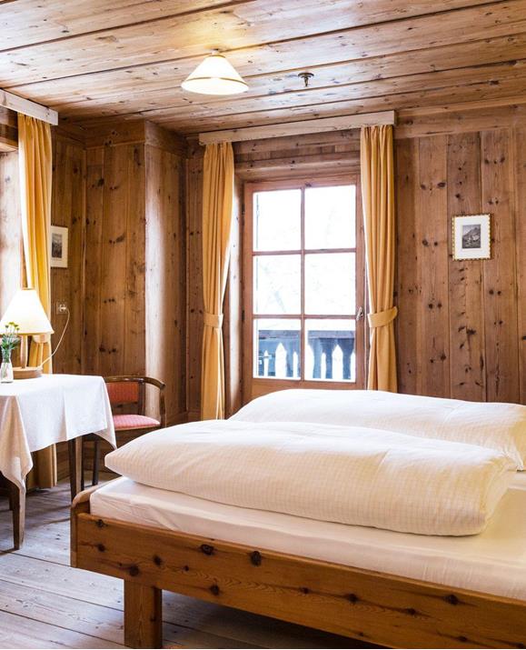 Das holzvertäfelte Doppelzimmer Zirbe mit Doppelbett, Balkon und Einrichtung im rustikalen Stil