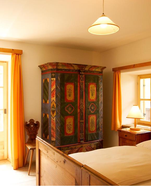 Eines der Schlafzimmer im Familiennest Garten mit zwei Einzelbetten, einem antiken Kleiderschrank und Zugang zur Terrasse